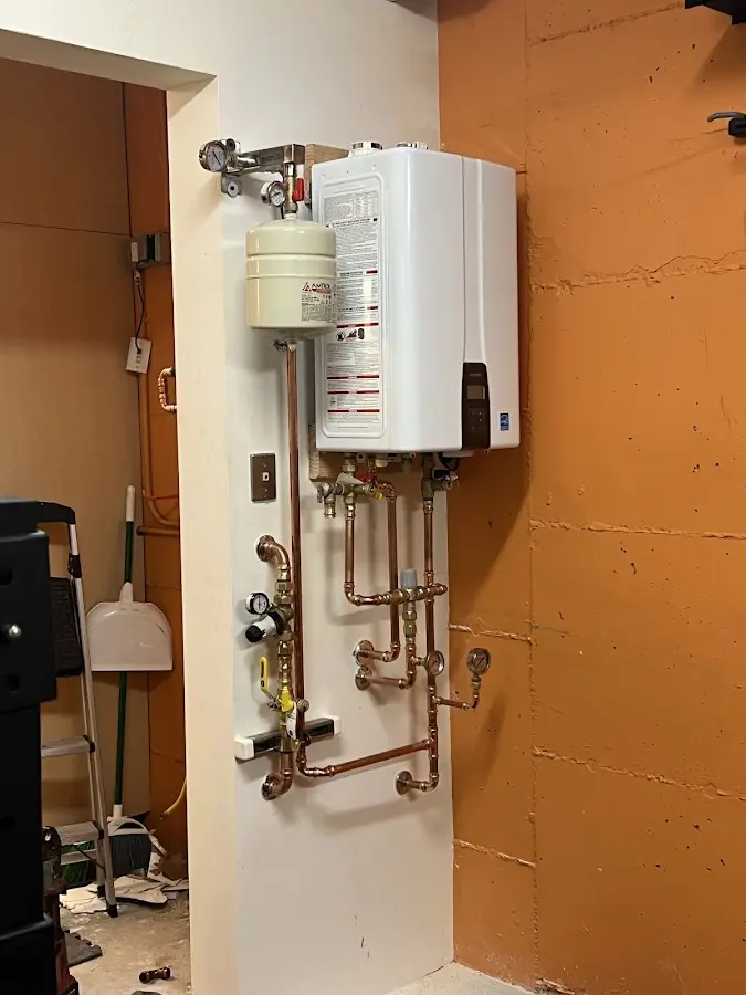 Plumbing technician inspecting water heater connections in Morgantown